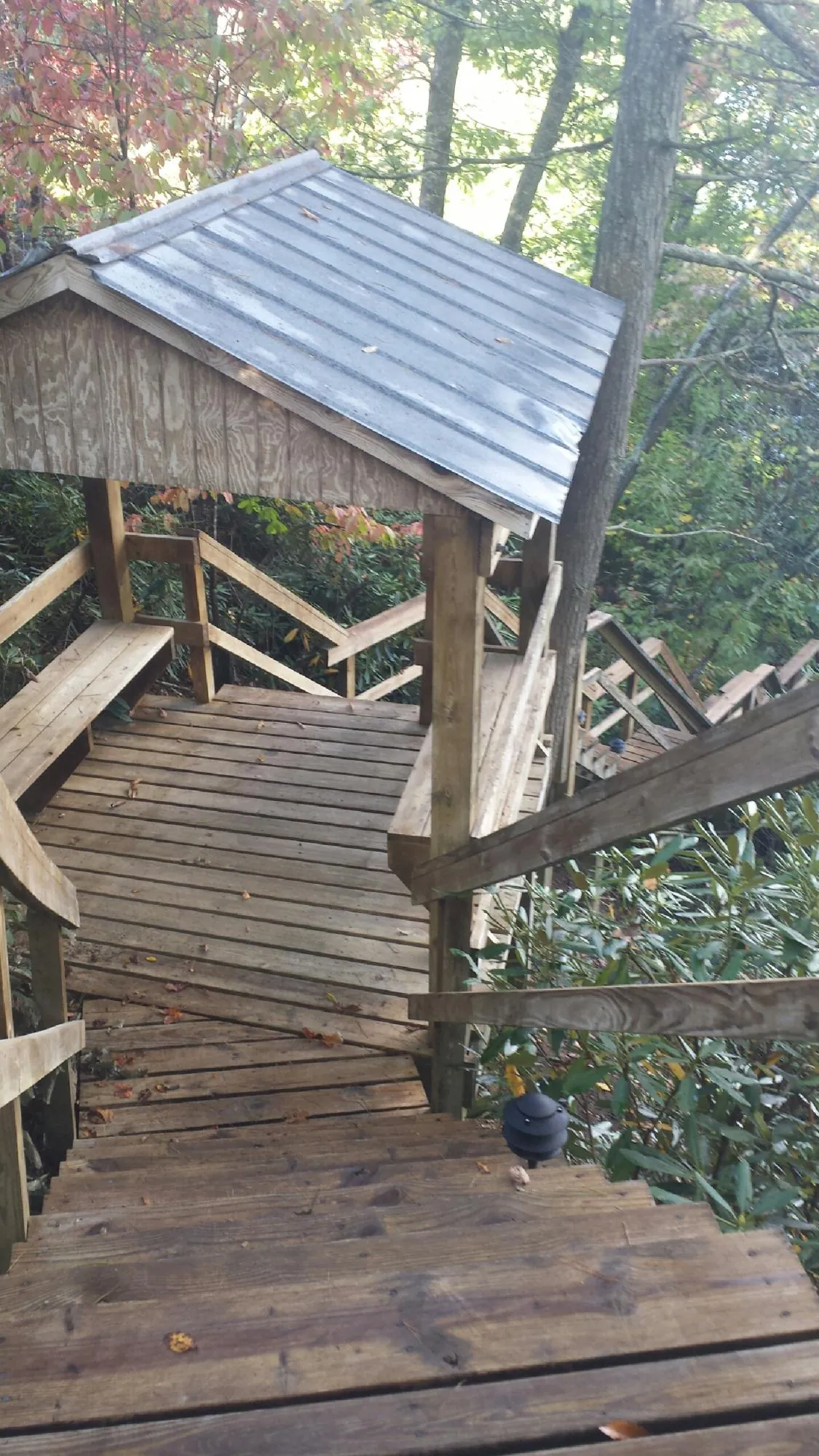 Metal roofed shelter over wooden steps on a wooded walkway — Skylight Repair & Installation work by our crew in Weirton