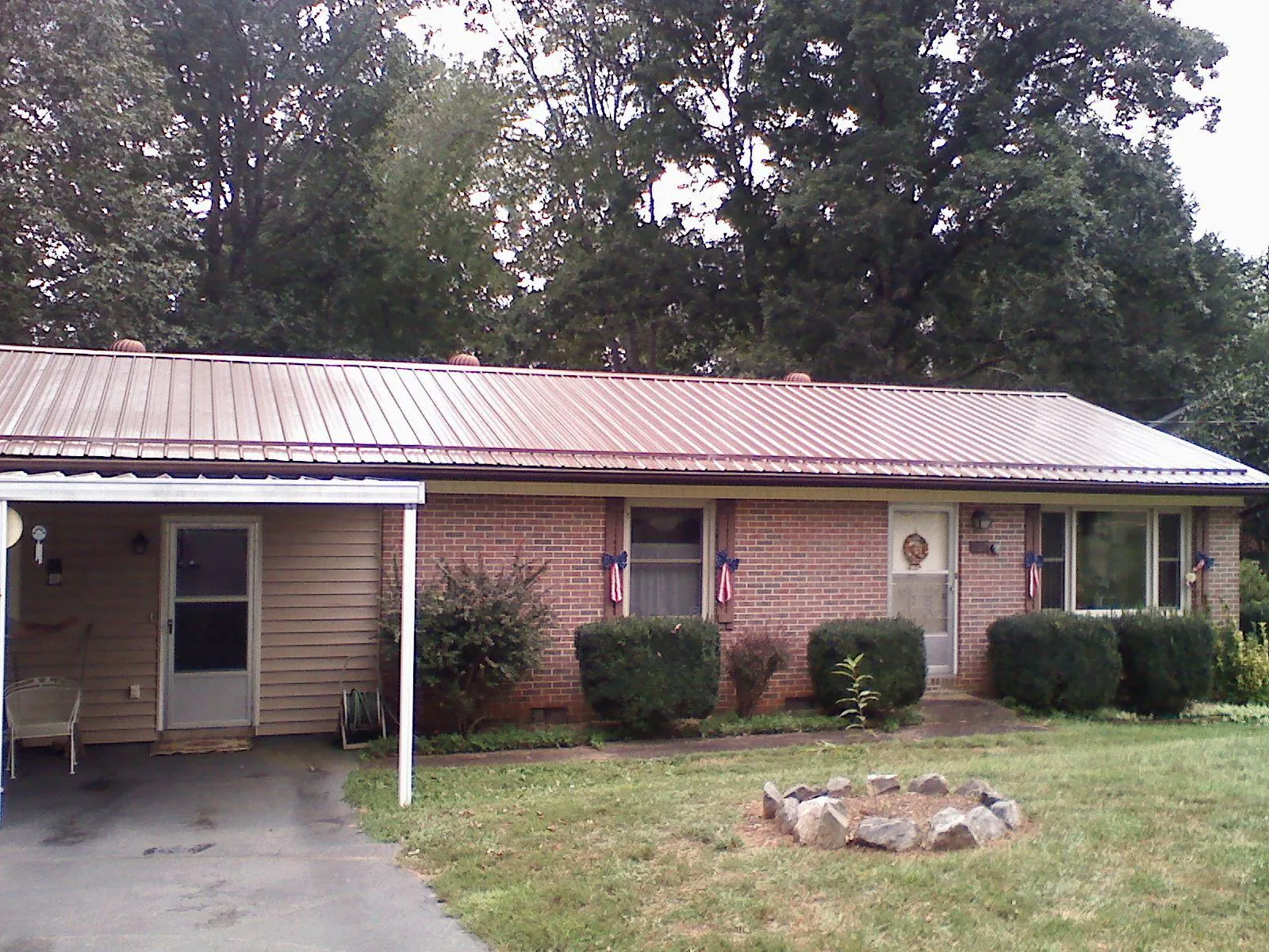 Bronze metal roof and carport on a brick ranch home — Roof Repair work by our crew in Weirton